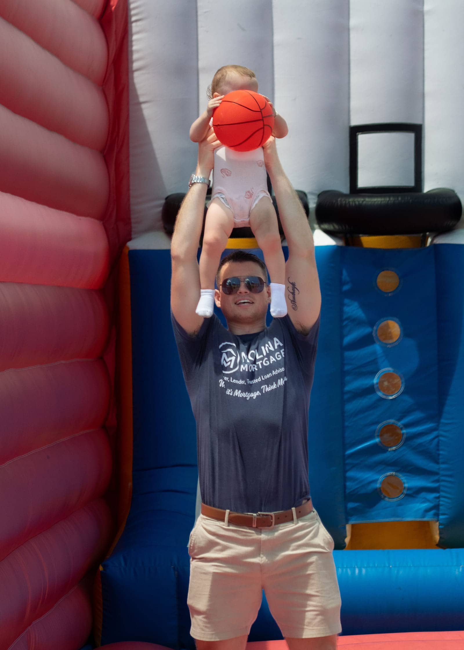 Christopher Molina lifting a child at the Molina Mortgage community family fun day